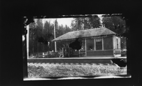 Print from large post card negative.  Hasting Rd Station. Two boys on bench, may be George and Robert Jones